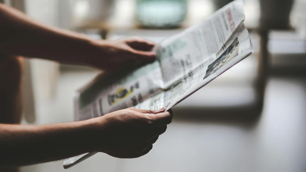 Hands holding an open newspaper